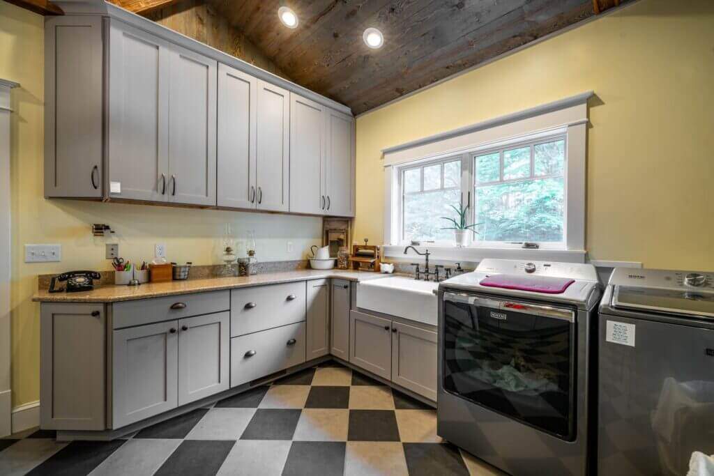 mudroom with gray cabinets and laundry